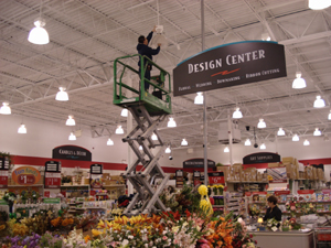 Employee on scaffold repairing lights